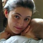 madre sosteniendo bebe sonriendo