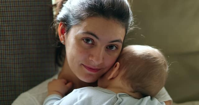 madre sosteniendo bebe sonriendo