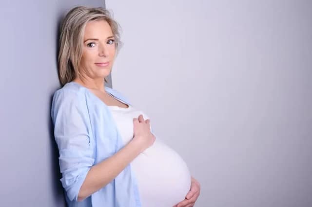 Embarazo en perimenopausia: mujer madura embarazada mostrando su vientre
