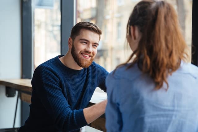 Acuerdo de coparentalidad: hombre y mujer conversando y planificando la crianza en un café